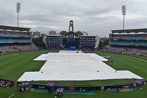 Ground staff cover the pitch as it rains prior to the ICC Women's Cricket World Cup match between India and Bangladesh, at DY Patil Stadium, in Navi Mumbai, Maharashtra.