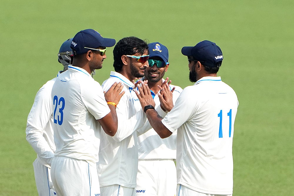 | Photo: PTI/Swapan Mahapatra : Bengal's Shahbaz Ahmed celebrates with teammates after dismissing Gujarat's Chintan Gaja on Day 3 of the Ranji Trophy match at Eden Gardens, Kolkata.
