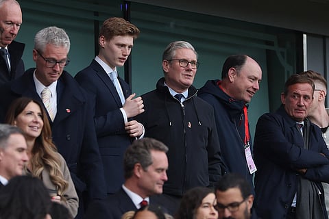 Britain's Prime Minister Keir Starmer stands on the tribune prior to the start of the English Premier League soccer match between Arsenal and Crystal Palace in London.