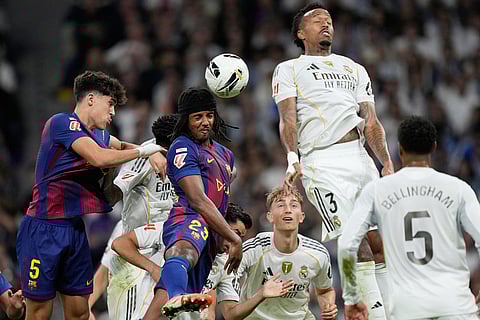 Barcelona's Jules Kounde heads the ball during a La Liga soccer match between Real Madrid and Barcelona in Madrid, Spain.

