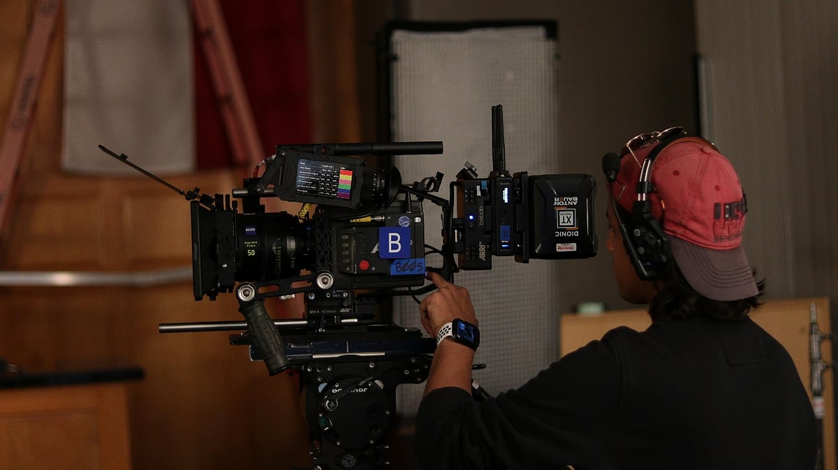 Filmmaker Vedant Dave operating a professional movie camera on a film set