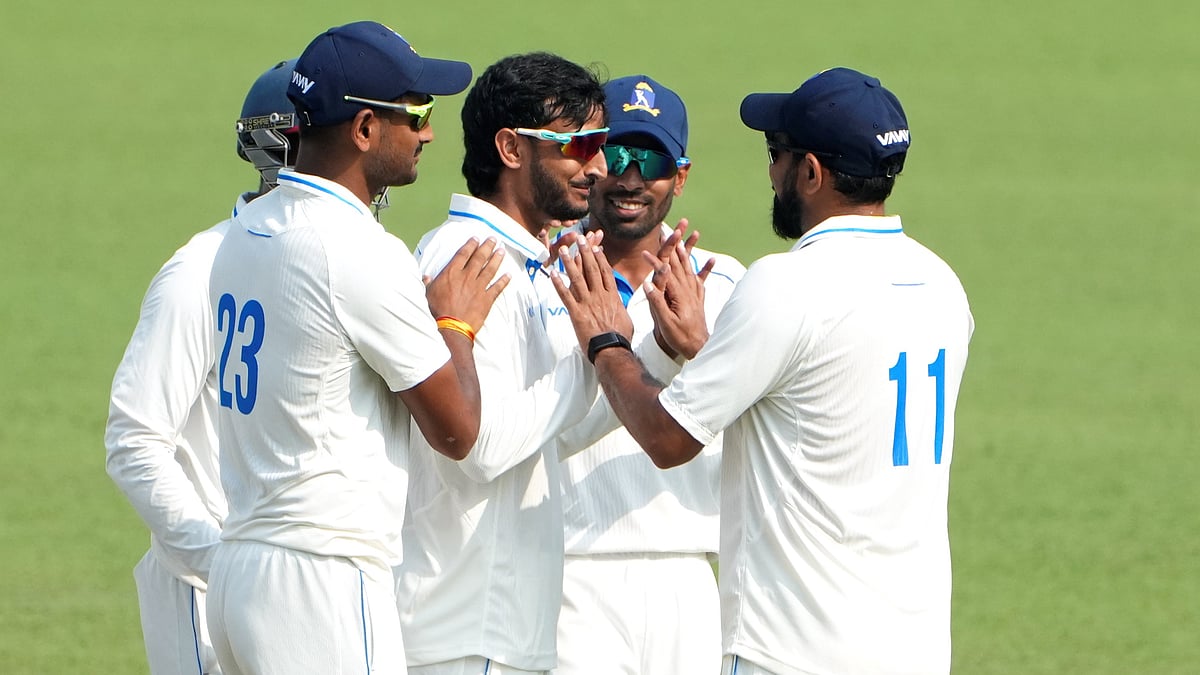 Photo: PTI : Bengal's Shahbaz Ahmed celebrates with teammates after dismissing Gujarat's Chintan Gaja on Day 3 of the Ranji Trophy match at Eden Gardens.