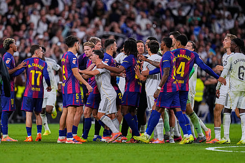 Real Madrid and Barcelona players scuffle during the Spanish La Liga soccer match between Real Madrid and Barcelona, in Madrid.