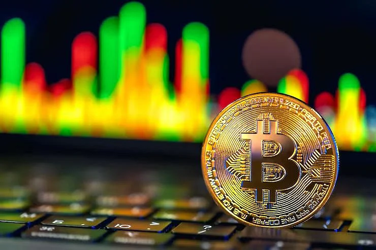 Golden Bitcoin on keyboard with market chart background