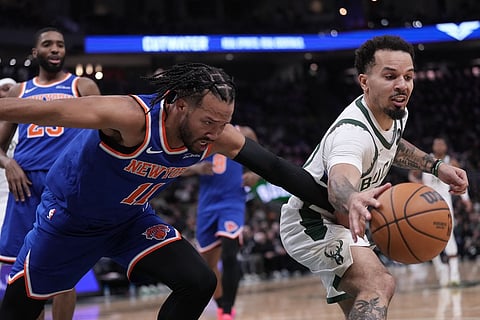 Milwaukee Bucks' Cole Anthony knocks the ball from New York Knicks' Jalen Brunson during the first half of an NBA basketball game in Milwaukee. 
