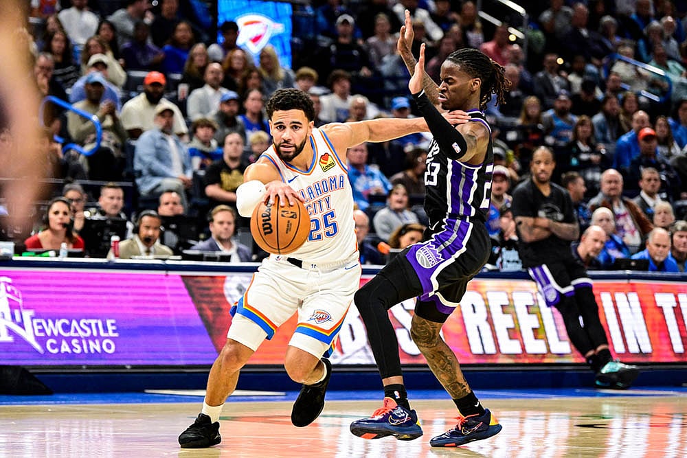 | Photo: AP/Gerald Leong : Oklahoma City Thunder guard Ajay Mitchell (25) drives pass Sacramento Kings guard Keon Ellis (23) during the second half of an NBA basketball game between Sacramento Kings and Oklahoma City Thunder in Oklahoma City. 