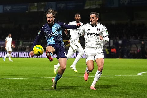 Wycombe Wanderers' Sam Bell, left, and Fulham's Timothy Castagne battle for the ball during the English League Cup fourth round soccer match between Wycombe Wanderers and Fulham, in High Wycombe, England.