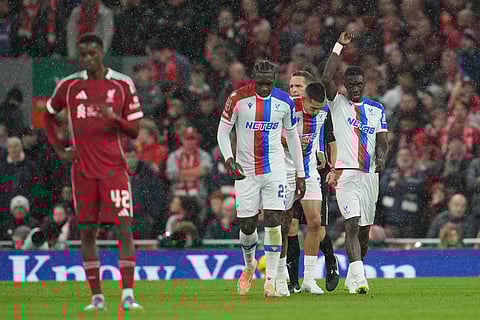 Crystal Palace's Ismaila Sarr, right, raises his hand after scoring during the English League Cup fourth round soccer match between Liverpool and Crystal Palace in Liverpool, England.