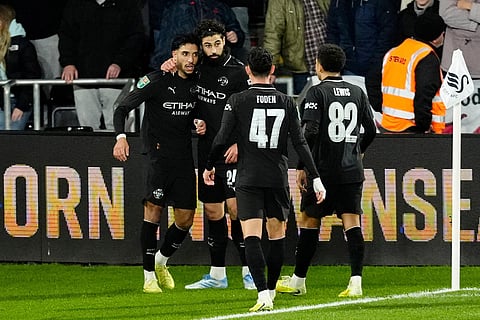 Swansea City vs Manchester City: Manchester City's Omar Marmoush, left, celebrates scoring with teammates during the English League Cup fourth round soccer match between Swansea City and Manchester City in Swansea, Wales.