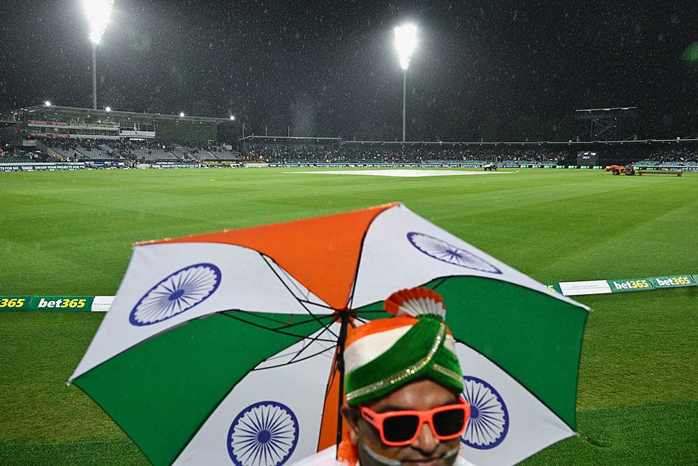 | Photo: Lukas Coch/AAPImage via AP : Indian fans wait as rain delays play during the T20 cricket international between India and Australia in Canberra, Australia.
