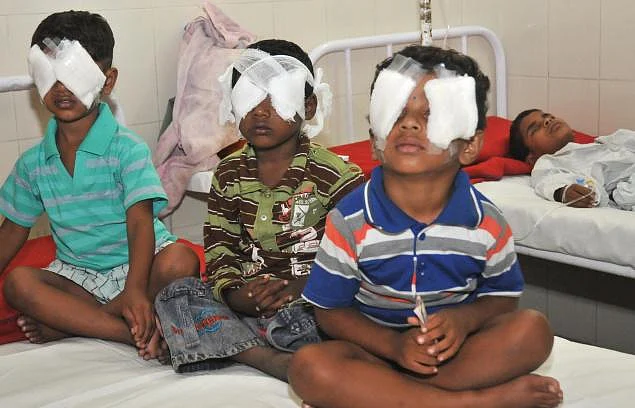 Children sitting in hospital with bandages on their eyes