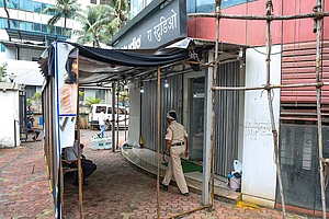 | Photo: PTI : A police official keeps a vigil outside R A Studio, where a man held 19 persons including 17 teenage children hostage yesterday, at Powai area, in Mumbai, Maharashtra.