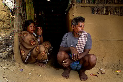 Jattu Paswan (55) and Saalti, from the Manjhi community, sit outside their basic shelter, relying on cutting and selling wood for a living. 