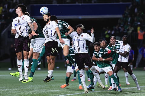 Jeison Medina of Ecuador's Liga Deportiva Universitaria (16) heads the ball next to Allan of Brazil's Palmeiras during a Copa Libertadores semifinal second leg soccer match in Sao Paulo.