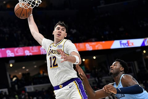 Los Angeles Lakers forward Jake LaRavia (12) grabs a rebound over Memphis Grizzlies forward Jaren Jackson Jr., right, in the second half of an NBA Cup basketball game in Memphis, Tenn.