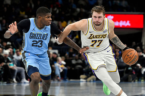 Los Angeles Lakers guard Luka Doncic (77) handles the ball against Memphis Grizzlies forward Cedric Coward (23) in the second half of an NBA Cup basketball game in Memphis, Tenn.