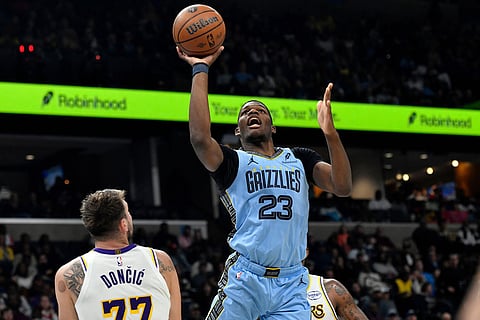 Memphis Grizzlies forward Cedric Coward (23) shoots over Los Angeles Lakers guard Luka Doncic (77) in the first half of an NBA Cup basketball game in Memphis, Tenn.