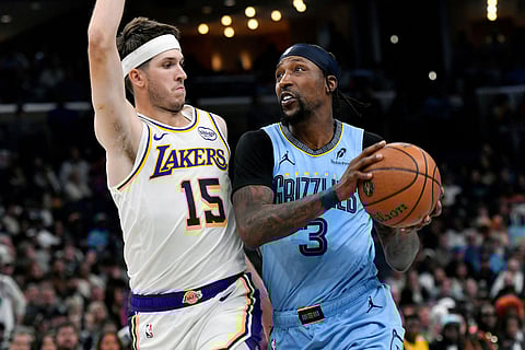 Memphis Grizzlies guard Kentavious Caldwell-Pope (3) handles the ball against Los Angeles Lakers guard Austin Reaves (15) in the first half of an NBA Cup basketball game in Memphis, Tenn.