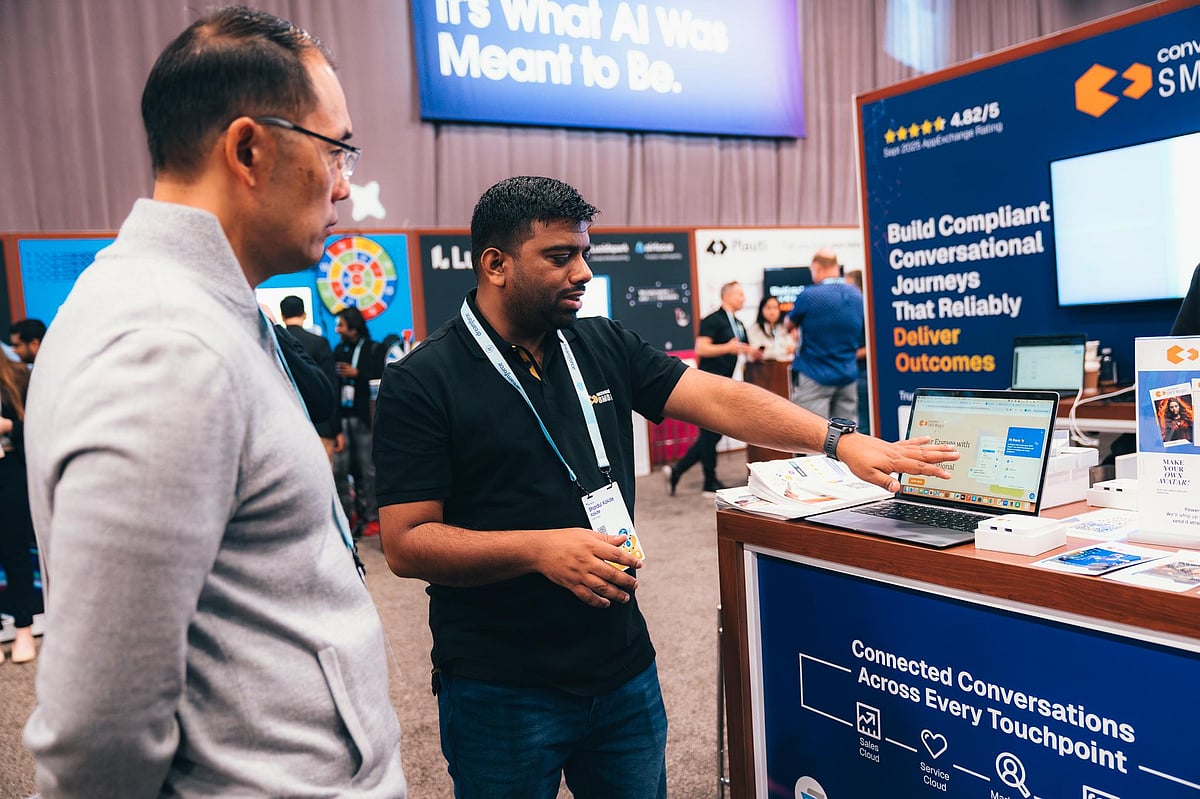 Two men talking at a tech event booth 