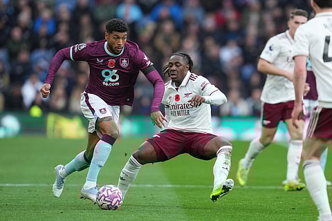 Burnley's Josh Laurent, left, challenges for the ball with Arsenal's Eberechi Eze during the English Premier League soccer match between Burnley and Arsenal in Burnley, England.