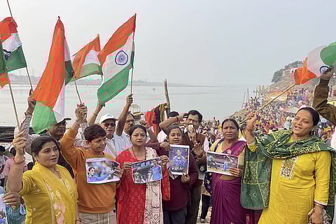People hold the national flag to show support ahead of the ICC Women's World Cup 2025 cricket match between India Women and South Africa Women, in Prayagraj.
