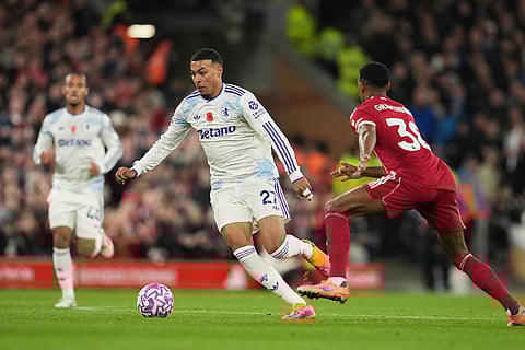 Aston Villa's Morgan Rogers, centre, challenges for the ball with Liverpool's Ryan Gravenberch during the English Premier League soccer match between Liverpool and Aston Villa in Liverpool, England.