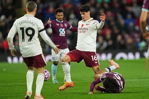 Arsenal's Christian Norgaard challenges for the ball with Burnley's Hannibal Mejbri, bottom, during the English Premier League soccer match between Burnley and Arsenal in Burnley, England.
