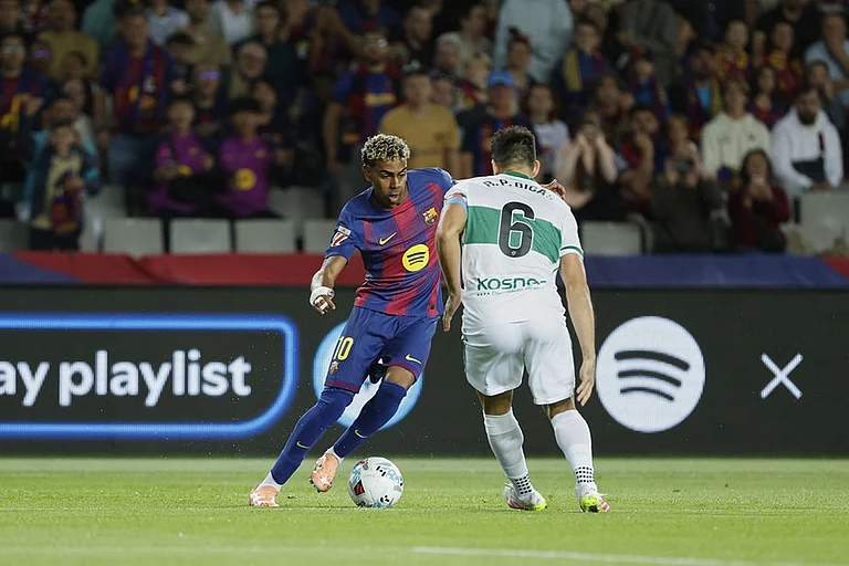 Barcelona's Lamine Yamal, left, is challenged by Elche's Pedro Bigas during a Spanish La Liga soccer match between FC Barcelona and Elche CF in Barcelona, Spain. - | Photo: AP/Joan Monfort