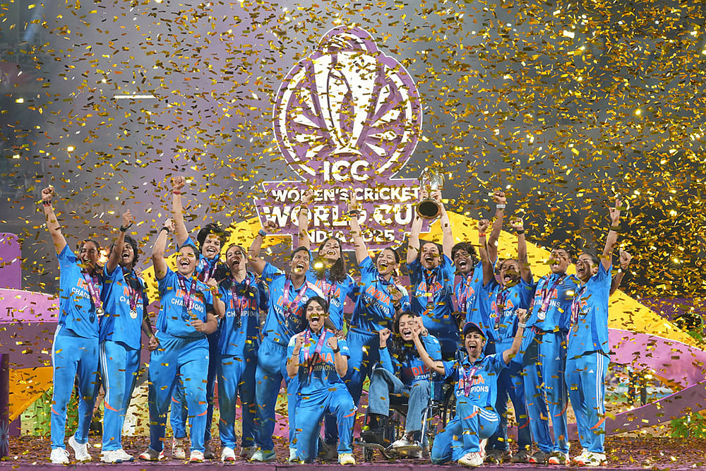 | Photo: AP/Rafiq Maqbool : India's players pose with the winning trophy after their win over South Africa in the ICC Women's Cricket World Cup final match in Navi Mumbai.