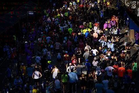 People walk and take photos after crossing the finish line of the New York City Marathon in New York. 