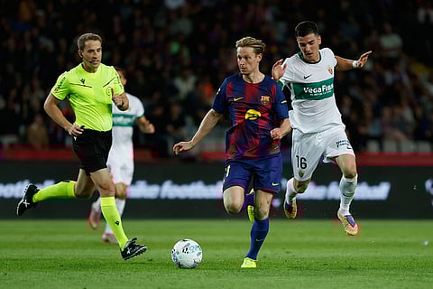 Barcelona's Frenkie de Jong, center, runs with the ball past Elche's Martim Neto during a Spanish La Liga soccer match between FC Barcelona and Elche CF in Barcelona, Spain.