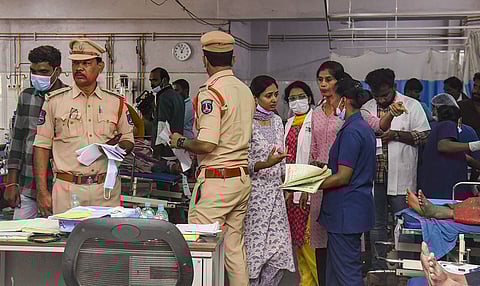 Police personnel at a hospital where injured are receiving treatment after a tipper lorry carrying gravel collided head-on with a public transport bus, in Ranga Reddy district, Telangana.