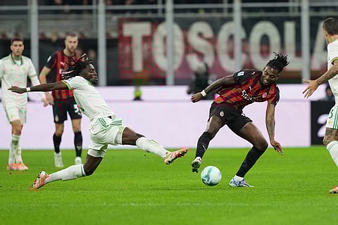 AC Milan's Rafael Leao, centre right, and Roma's Manu Kone challenge for the ball during the Serie A soccer match between AC Milan and Roma in Milan, Italy.
