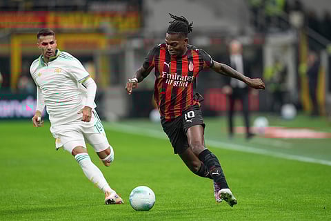 AC Milan's Rafael Leao, right, and Roma's Zeki Celik challenge for the ball during the Serie A soccer match between AC Milan and Roma in Milan, Italy.
