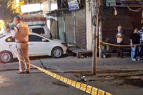 A policeman investigates the spot after a man was shot dead, at Geeta Colony in New Delhi.