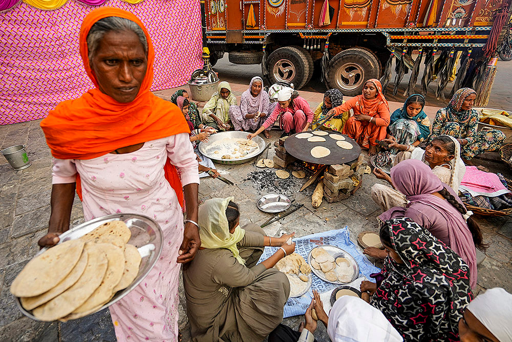 | Photo: PTI/Shiva Sharma : Volunteers prepare 'langar' on the eve of the birth anniversary of founder of Sikhism Guru Nanak Dev, in Amritsar.