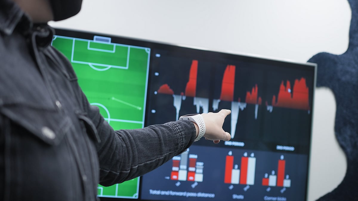 A person pointing at a screen with football analytics graphics