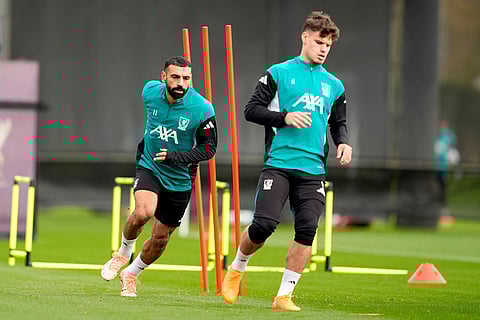Liverpool's Mohamed Salah, left, runs during a training session in Liverpool, England, ahead of the Champions League soccer match against Real Madrid.