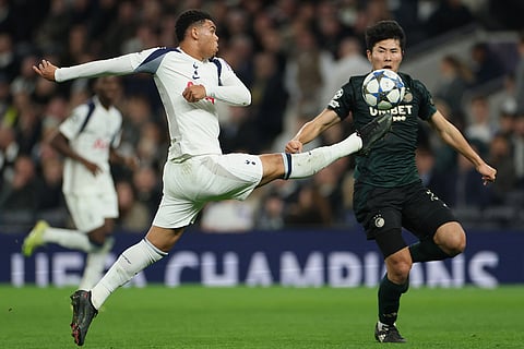 Tottenham's Dane Scarlett, left, duels for the ball with Copenhagen's Junnosuke Suzuki during the Champions League opening phase soccer match between Tottenham and Copenhagen, in London, England.