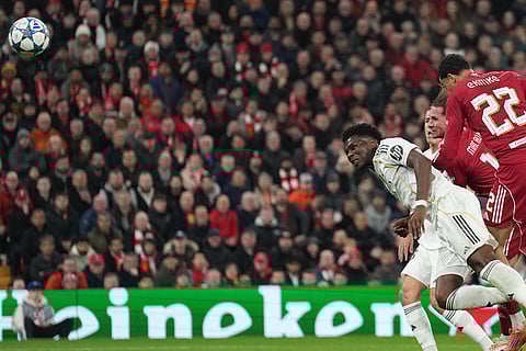 Liverpool's Alexis Mac Allister, center, scores a header during the Champions League soccer match between Liverpool and Real Madrid in Liverpool, England.