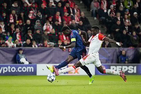 Arsenal's Bukayo Saka, left, attempts a shot at goal in front of Slavia's Youssoupha Mbodji during the Champions League opening phase soccer match between Slavia Prague and Arsenal in Prague, Czech Republic.