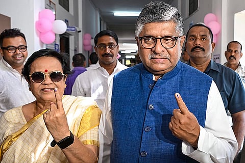 BJP MP Ravi Shankar Prasad and his wife show their ink marked finger after casting votes at a polling station during the first phase of the Bihar Assembly elections, in Patna.