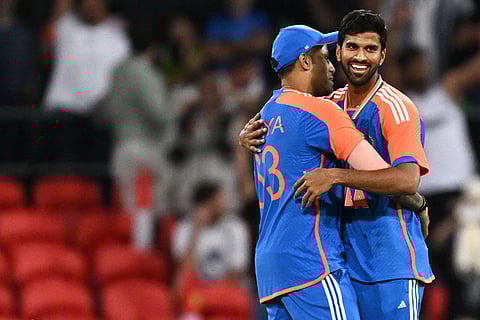 Washington Sundar, right, is congratulated by teammate Suryakumar Yadav after taking a wicket during a T20 cricket international between India and Australia in Carrara, Australia.