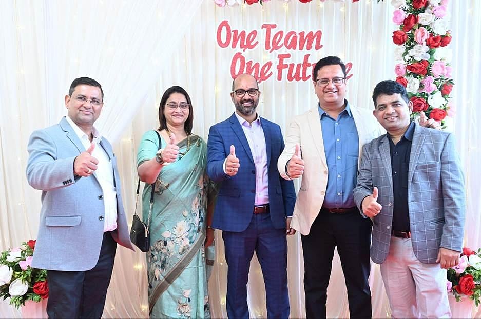 RUGR and SIPL team members posing together with “One Team One Future” backdrop.