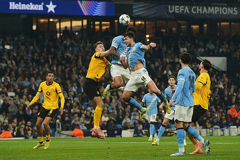 Manchester City's Nico Gonzalez, foreground, and Nico O'Reilly go for a header during the Champions League opening phase soccer match between Manchester City and Borussia Dortmund in Manchester, England.