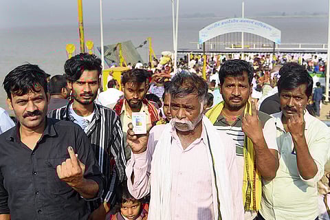 Voters show their ink-marked fingers as they deboard a ferry after casting their votes during the first phase of the Bihar Assembly elections, at Danapur in Patna.