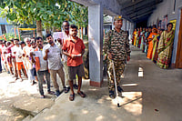 54% Voter Turnout In Bihar By 3 PM; Deputy CM Alleges Attack, Lalu Calls For Change Of Leadership | Photo: PTI : A security official keeps vigil as voters wait in queues to cast votes at a polling station during the first phase of the Bihar Assembly elections, in Patna.