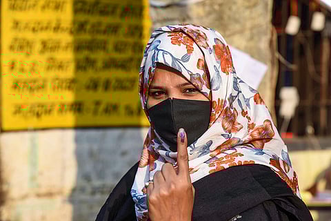 A woman shows her ink marked finger after casting vote at a polling station during the first phase of Bihar Assembly elections, in Patna.