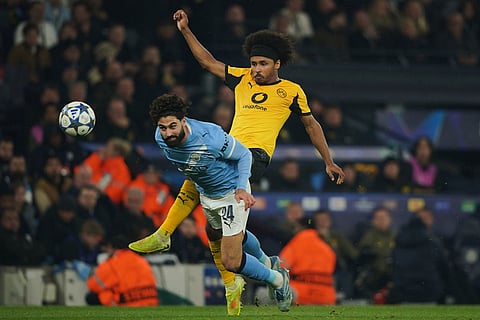 Manchester City's Josko Gvardiol, foreground, and Dortmund's Karim Adeyemi challenge for the ball during the Champions League opening phase soccer match between Manchester City and Borussia Dortmund in Manchester, England.