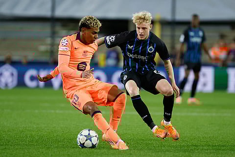 Barcelona's Lamine Yamal, left, and Brugge's Joaquin Seys fight for the ball during the Champions League opening phase soccer match between Club Brugge and Barcelona in Bruges, Belgium.